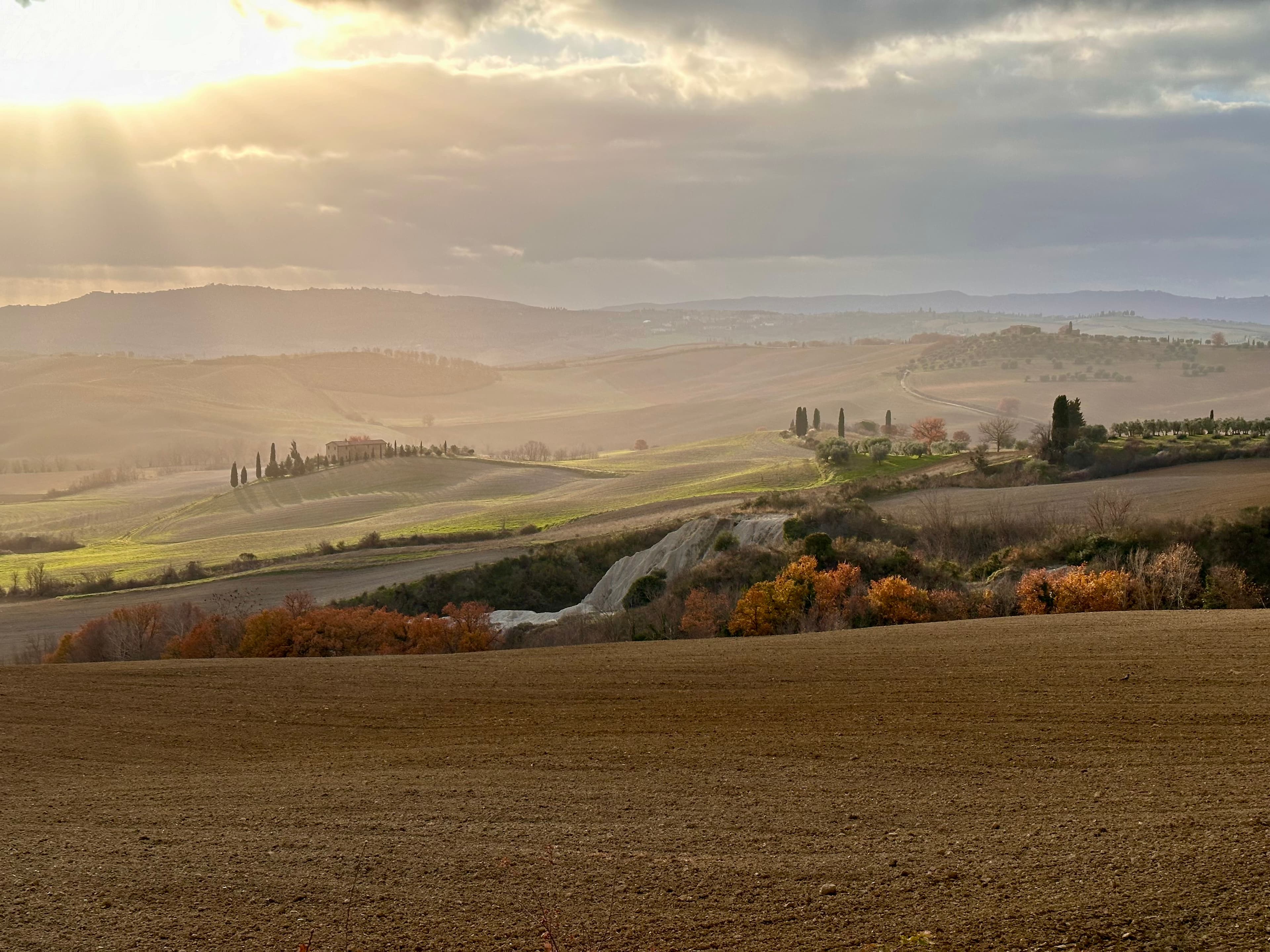 Val d'Orcia under dramatic storm light — classic podere landscape